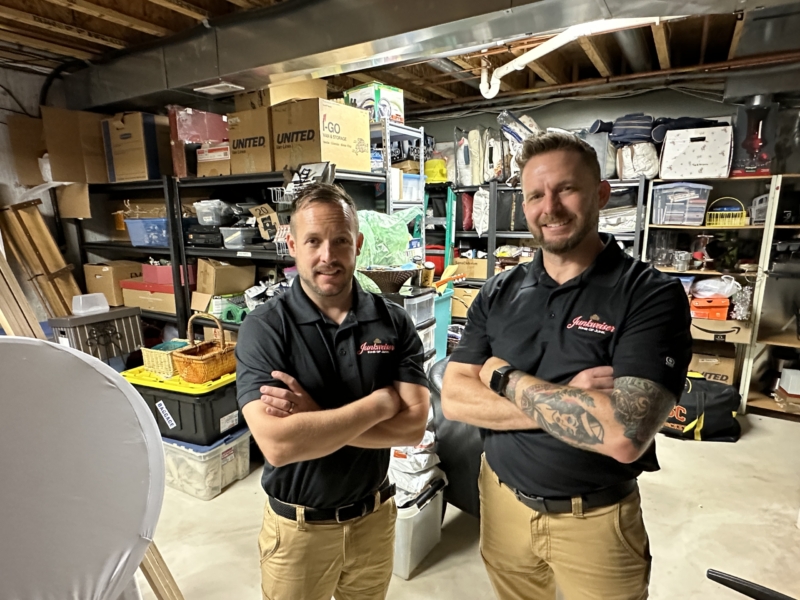 Junkweiser experts posing in a cluttered space before performing a clean out service